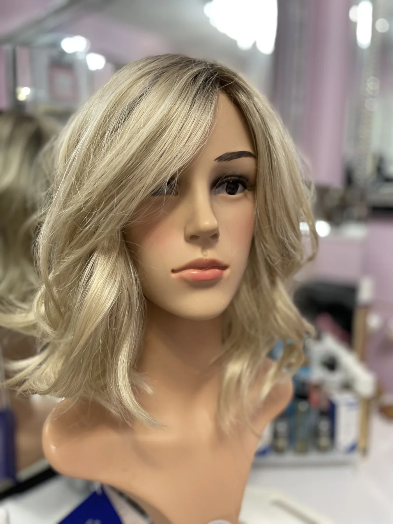 A softly waved blonde wig displayed in the studio